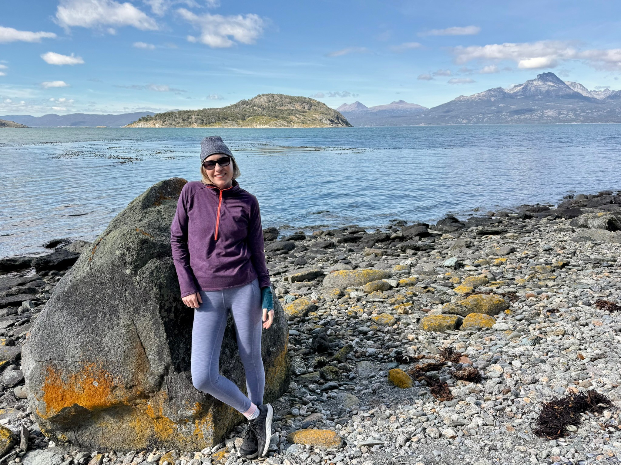 Shannon DeCock standing in front of a lake and mountains while traveling in Ushuaia, Argentina
